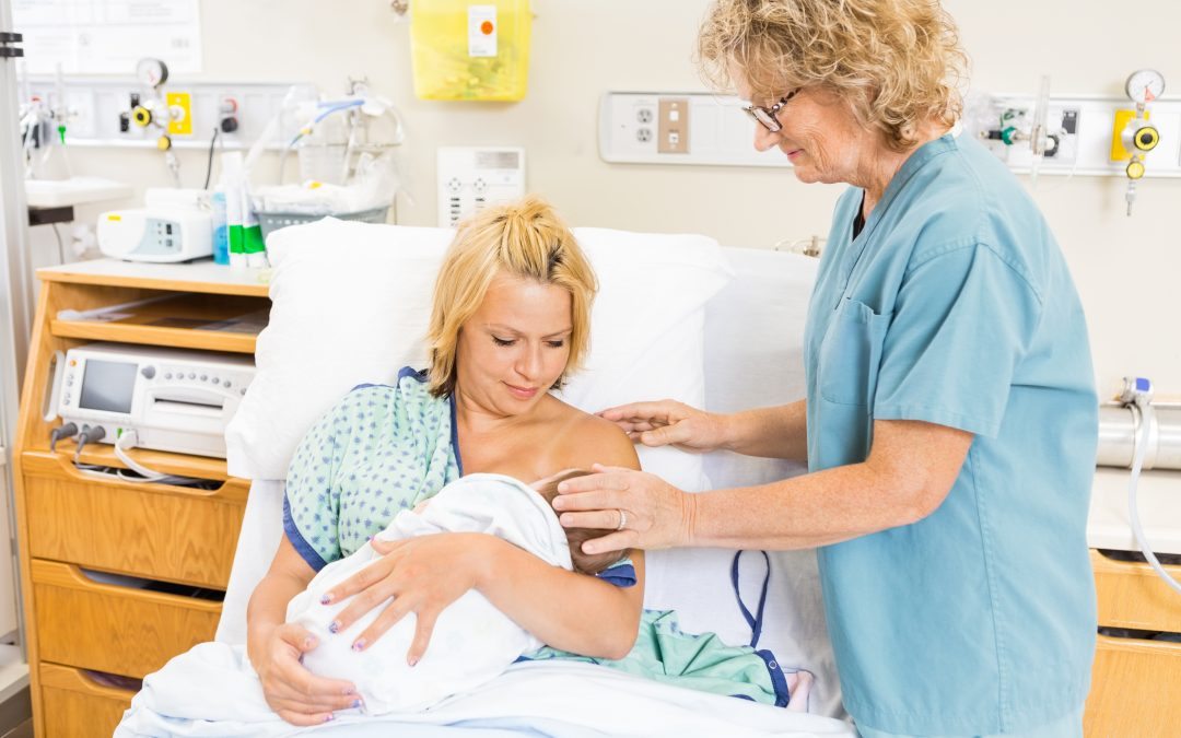 Lactation consultant assists new mom with breastfeeding.